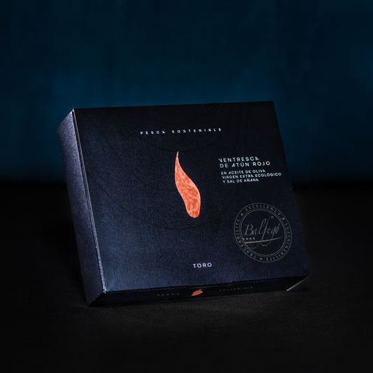 Der BALFEGO-THUNFISCHBAUCH IN OLIVENÖL von Balfego verfügt über eine dunkle Verpackung mit elegantem Design, einschließlich einer roten Fischgrafik und einem spanischen Text, der Balfegos Engagement für nachhaltigen Thunfisch (nachhaltiger Fang) betont.