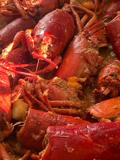 Rittmeyers Besondere Raffinessen HUMMER-ZITRONENGRASSUPPE: gekochter Hummer in einer würzigen, thailändisch inspirierten Brühe mit sichtbaren Scheren, Schalen und zarten Fleischstücken.
